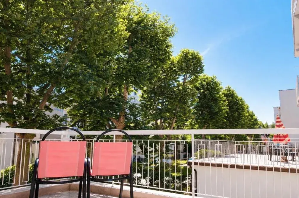 Balcone dell’hotel con sedie e vista sugli alberi