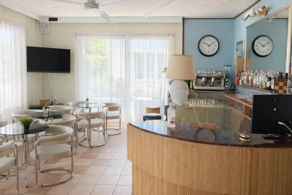 Bar e sala comune con tavoli e televisore