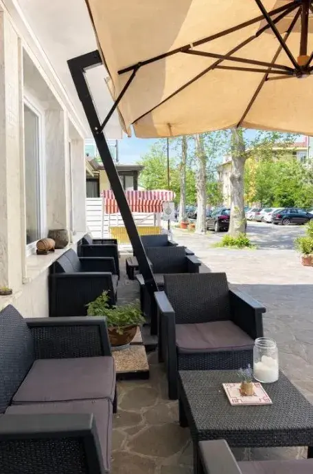 Terrazza coperta dell’hotel con poltrone e ombrelloni